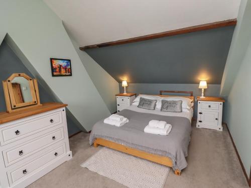 a bedroom with a bed and a dresser and a mirror at Number Seventeen in Amble