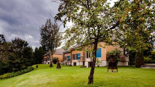 a house with a tree in the yard at Centre de Villégiature Dam-en-Terre in Alma