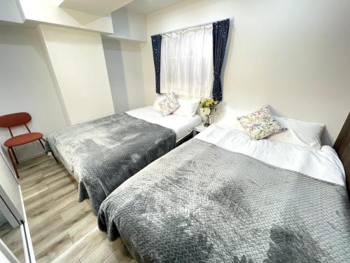 a bedroom with two beds and a window at Nishi-Ike Apartment Room 1 in Tokyo