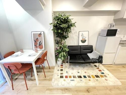 a living room with a black leather couch and a table at Nishi-Ike Apartment Room 1 in Tokyo