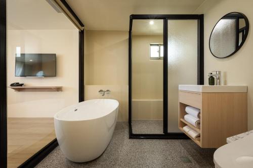 a bathroom with a large white tub and a sink at Hotel Ever Spring - Penghu in Magong
