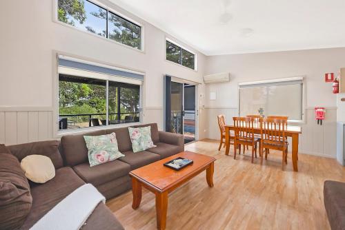 a living room with a couch and a table at Reflections Tuncurry - Holiday Park in Tuncurry