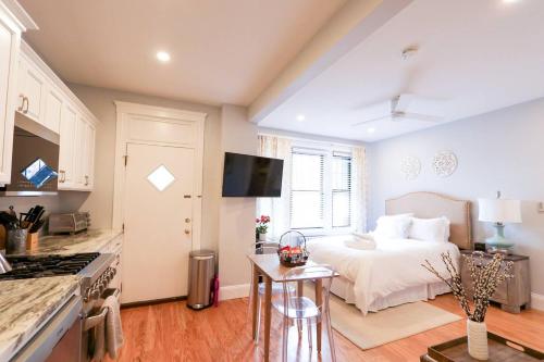 a bedroom with a bed and a kitchen with a stove at Sunny,cozy,near Bc,bu,boston,mbta in Boston