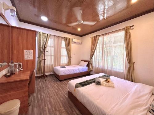 a hotel room with two beds and a desk at Galaxy Sunrise Sea View in Fulidhoo