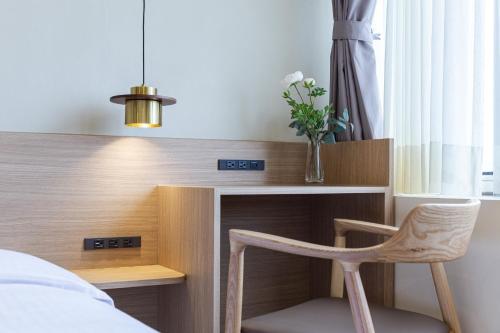 a bedroom with a desk and a chair next to a bed at Hotel Ever Spring - Penghu in Magong