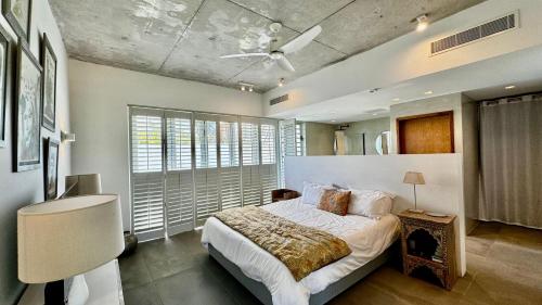 ein Schlafzimmer mit einem Bett und einem großen Fenster in der Unterkunft Garden Villa with pool in Petit Raffray