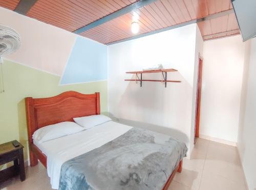 a bedroom with a bed and a shelf on the wall at La Rosa Náutica Club in Guaduas
