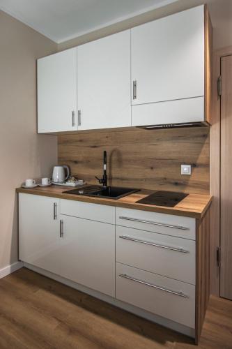 a kitchen with white cabinets and a sink at Soul House Gdansk Old Town in Gdańsk