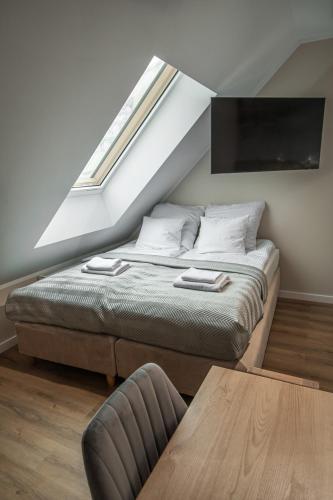 a bedroom with a bed with a window and a table at Soul House Gdansk Old Town in Gdańsk