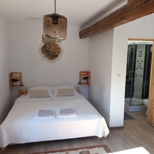 a bedroom with a white bed and a chandelier at Dom w górach Przy szlaku in Bystra