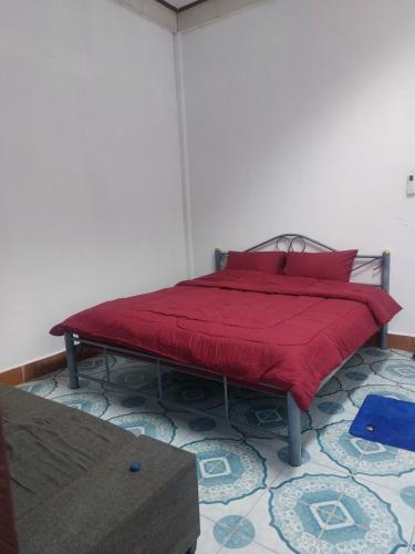 Mabuhay Guest House في فيينتيان: سرير في غرفة مع بطانية حمراء عليه