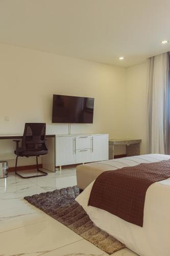 Hotel Estoril في بيرا: غرفة نوم بسرير وتلفزيون على جدار
