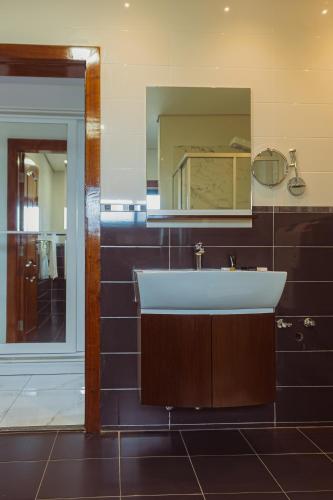 Hotel Estoril في بيرا: حمام مع حوض ومرآة