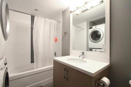 y baño con lavabo y lavadora. en QE Park Garden suite 3BR 1.5Ba, en Vancouver