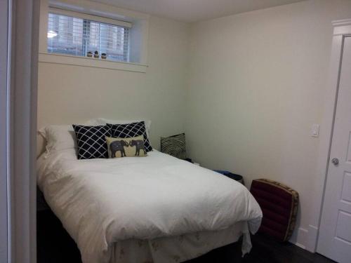 溫哥華的住宿－QE Park Garden suite 3BR 1.5Ba，卧室配有白色的床和两个枕头