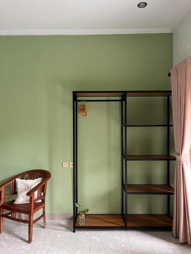 a room with a green wall with a bunk bed at Nomad Cottage in Amed