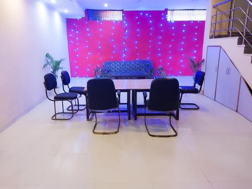 a table and chairs in a room with a purple wall at Roomshala 002 Rose Residency Near Yashobhoomi in New Delhi