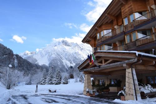 a ski lodge with a snow covered mountain in the background at Hotel Garni Pegrà in Ponte di Legno