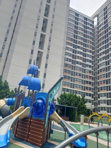 a playground in front of a large building at Horizon Suite Kila Short-term hotel in Sepang