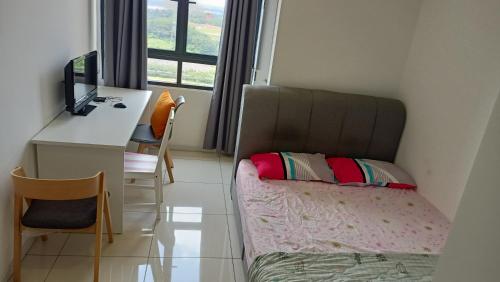 a small room with a bed and a desk with a computer at Horizon Suite Kila Short-term hotel in Sepang