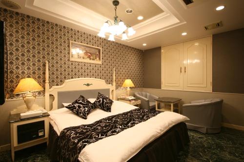 um quarto com uma cama grande e almofadas pretas e brancas em D-CUBE奈良店 em Nara