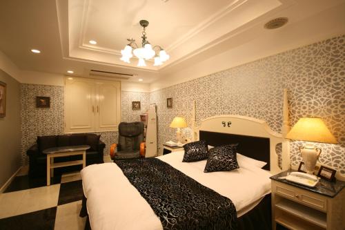 a hotel room with a bed and a chair at D-CUBE奈良店 in Nara