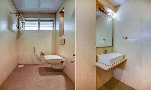 een badkamer met een wastafel, een toilet en een spiegel bij Hotel Shree Daan in Vapi