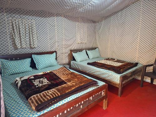 a room with two beds in a room at Haveli Resort in Rishīkesh