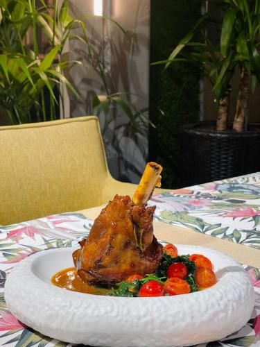 a chicken on a plate with vegetables on a table at Hotel Brilliant Meseș in Zalău