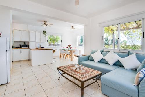 een woonkamer met een blauwe bank en een tafel bij Ayia Thekla Serenity Villa in Ayia Napa