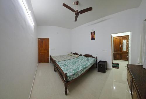 a bedroom with a bed and a ceiling fan at Meadow Heaven Home Stay in Munnar