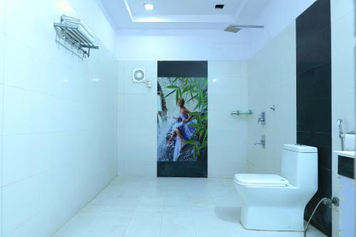 La salle de bains est pourvue de toilettes et d'une peinture murale. dans l'établissement Embassy Suites, à New Delhi