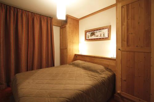 une chambre avec un lit dans une pièce avec une fenêtre dans l'établissement Val Ecrins - 11 - Appart de charme- 8 pers, à Les Deux Alpes