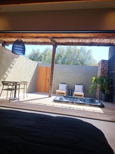 a bedroom with a hot tub on a deck at Hôtel Les Suites Du Maquis in Bonifacio