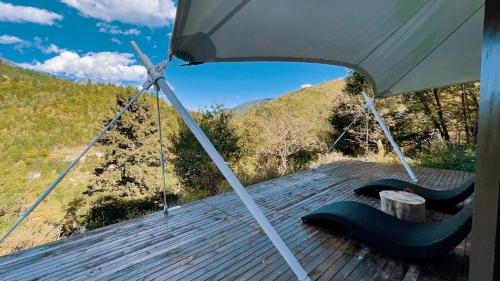 a porch with swings and an umbrella on a deck at Jiuzhaigou Valley Abluzi B&B-Free shuttle service to Jiuzhaigou Scenic Area in Jiuzhaigou