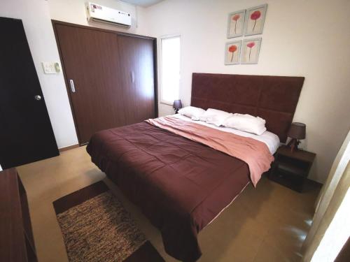 a bedroom with a large bed with red sheets and white pillows at KARA CASA in Arpora
