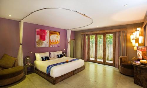a bedroom with a large bed in a room with purple walls at Blue Karma Dijiwa Seminyak in Seminyak
