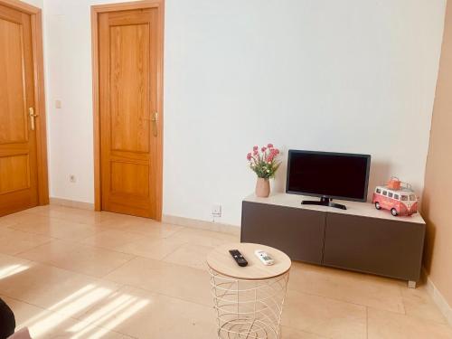 a living room with a television and a table with a stool at APARTAMENTO 2p MENDIVIL MADRID CENTRO in Madrid