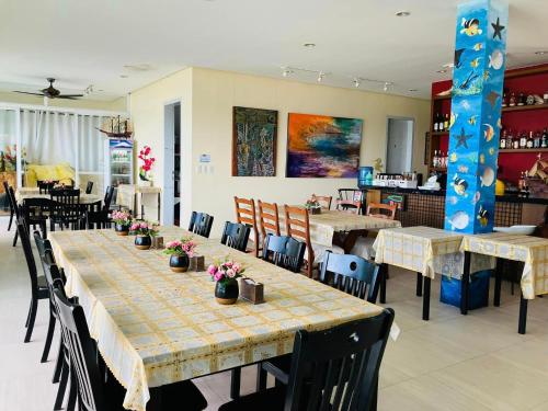 a dining room with tables and chairs with flowers on them at Paradiso Rito in Mabini