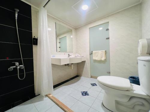 a bathroom with a toilet and a sink and a shower at Zhao Lai Hotel in Kaohsiung