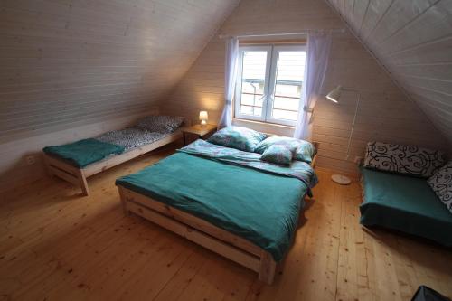 a attic bedroom with two beds and a window at Nowabobolin domki in Bobolin