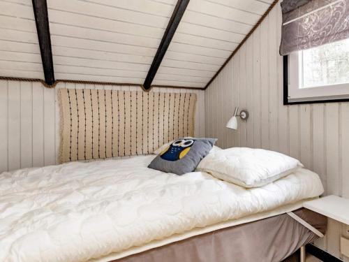 Bett in einem Zimmer mit Dachschräge in der Unterkunft Holiday home Hals LXXIII in Hals