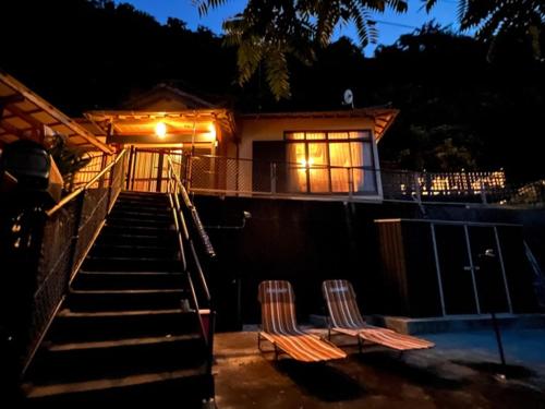 two chairs sitting in front of a house at night at Iojima BeachHouse - Vacation STAY 97622v in Nagasaki
