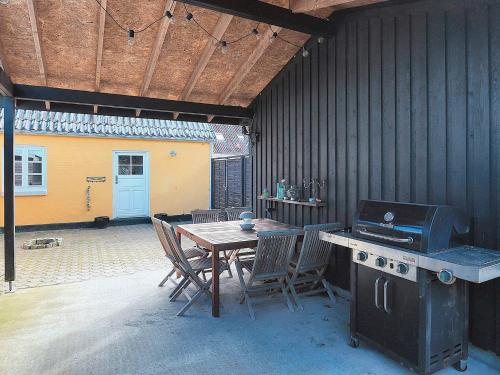 an outdoor patio with a table and a grill at 4 person holiday home in Ålbæk-By Traum in Ålbæk