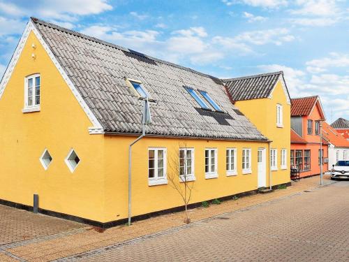 a yellow building with a gray roof on a street at 4 person holiday home in Ålbæk-By Traum in Ålbæk