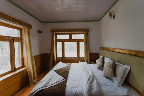 a bedroom with a large bed with a window at Hotel Lumbini in Leh