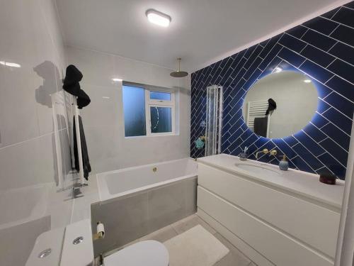a bathroom with a tub and a toilet and a mirror at Carrigaline Delightful Home in Carrigaline