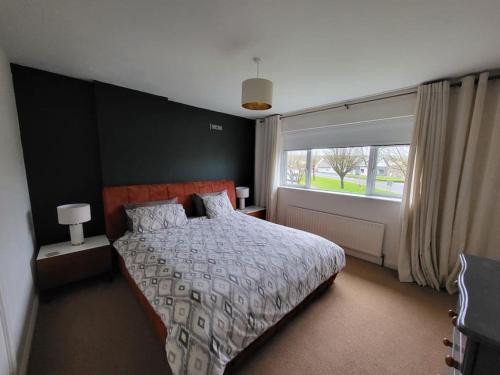 a bedroom with a bed and a large window at Carrigaline Delightful Home in Carrigaline