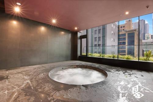Habitación con bañera grande en medio de un edificio en Rest Highrise City View Apt Melbourne Central en Melbourne