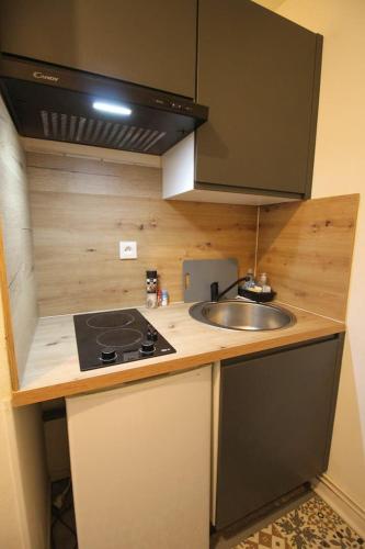 une petite cuisine avec un évier et une cuisinière dans l'établissement Le République Grand Studio Wi-Fi / Netflix, à Angoulême